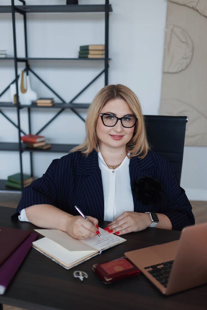 Евгения Мазка работает с документами за столом